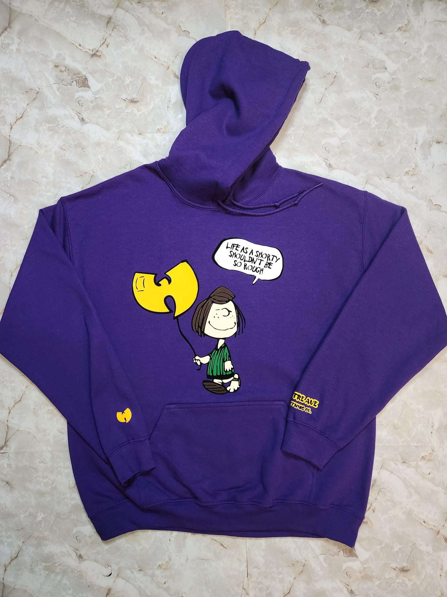 Purple hoodie with cartoon character design on a light gray surface